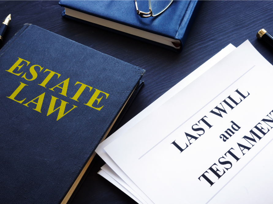 a book titled estate law sits next to a last will and testament