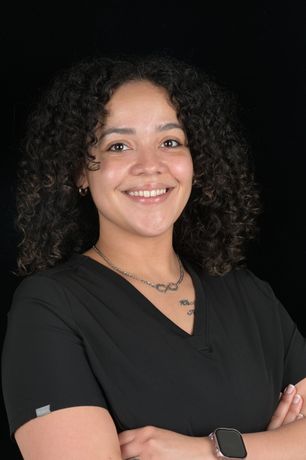 Woman in black scrubs smiles; 