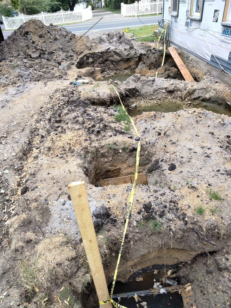 a large pile of dirt is being excavated in front of a house .