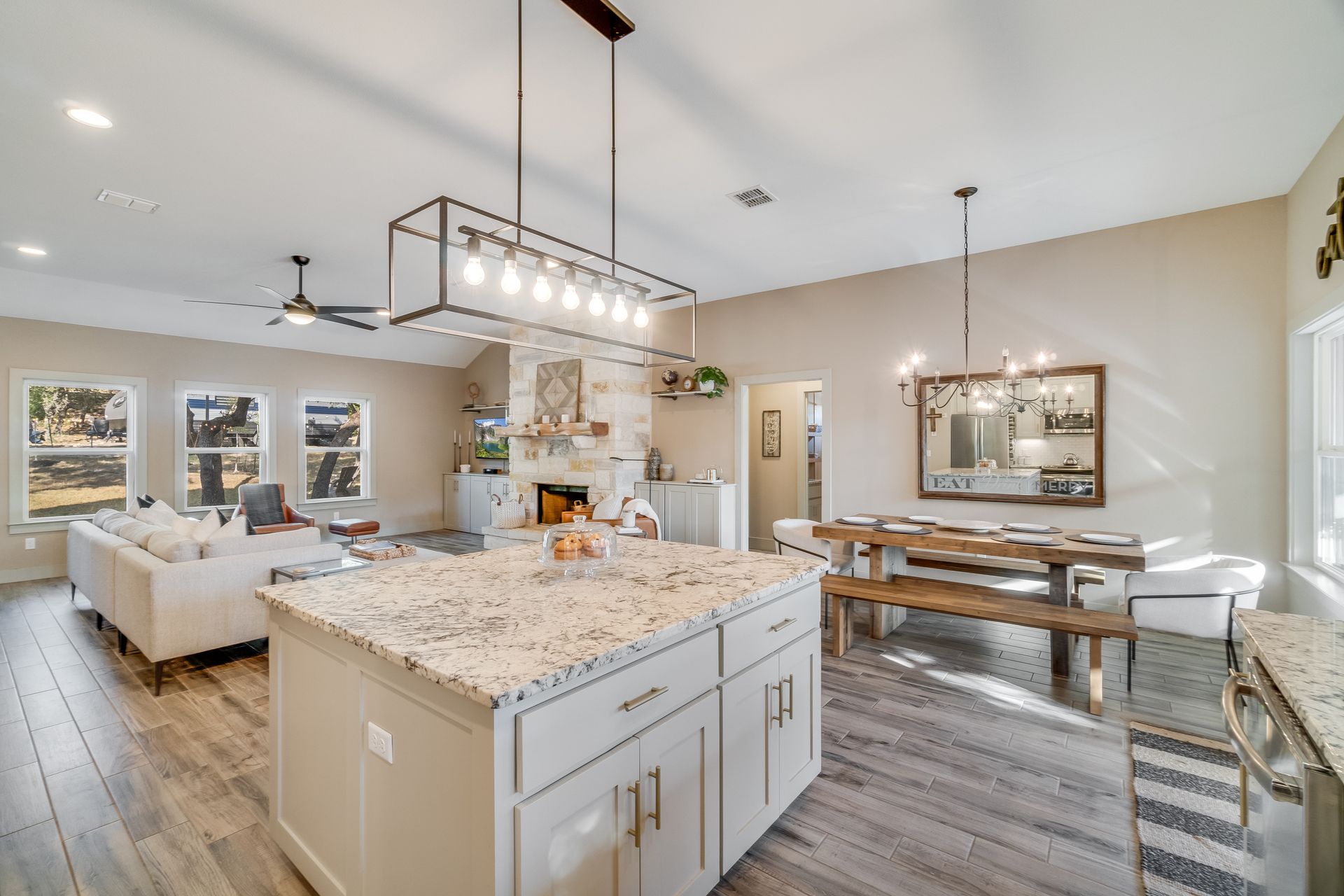 Modern open-concept kitchen and dining area with a large island, fireplace, and dining table.