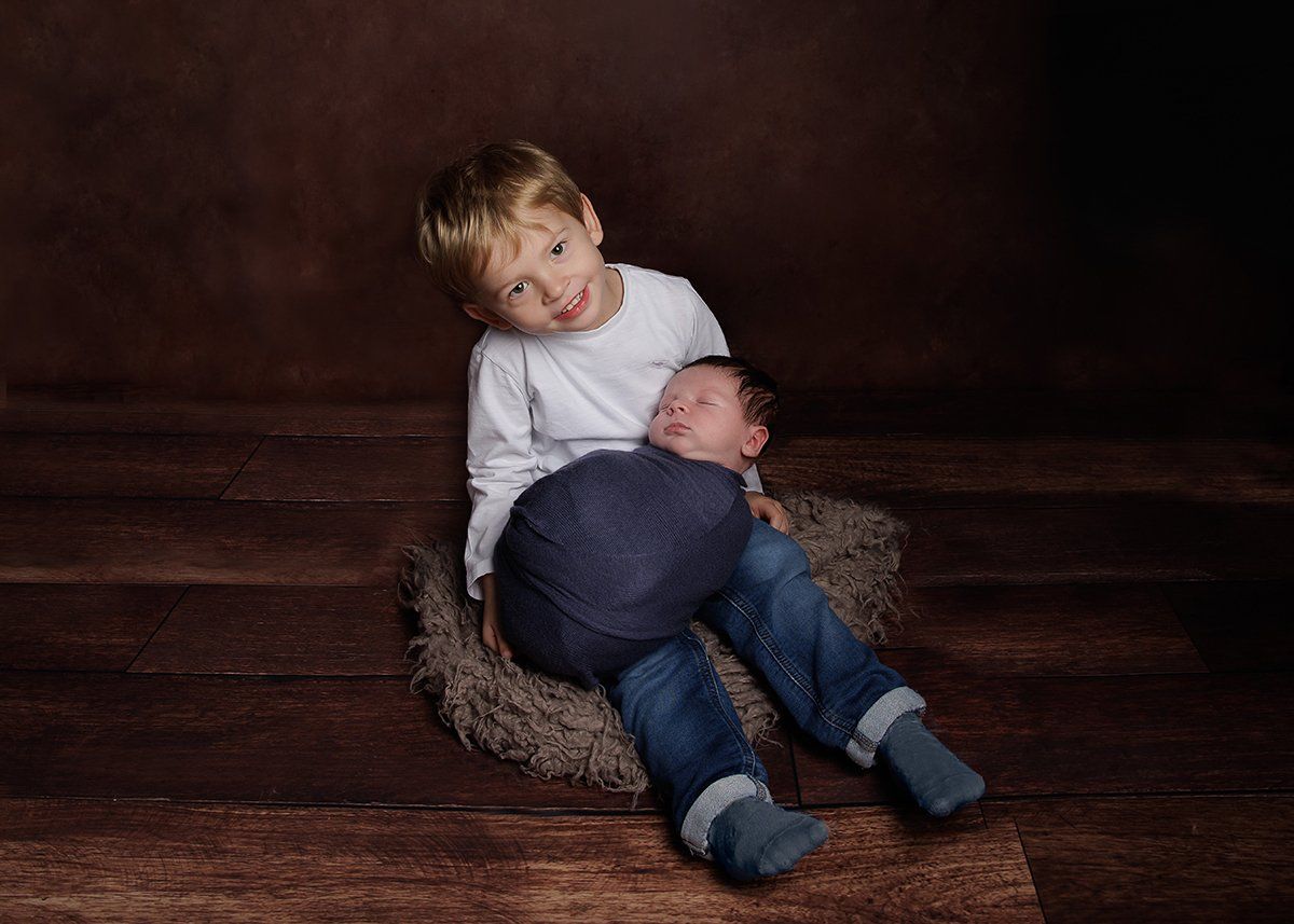 3-year old holding his newborn brother