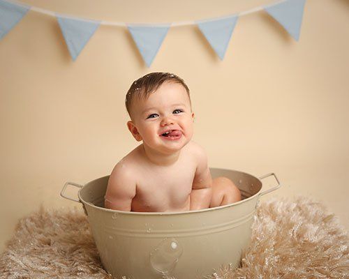 One year old baby girl in a milk bath with flowers