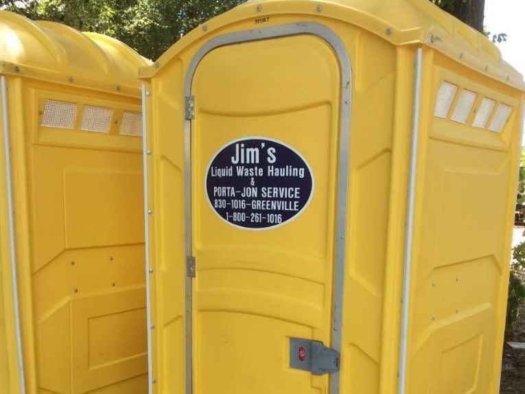 Two yellow portable toilets with jim 's on the door
