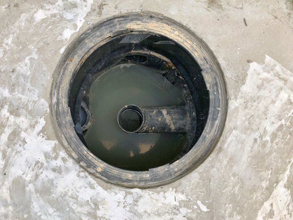 A close up of a drain with water coming out of it.