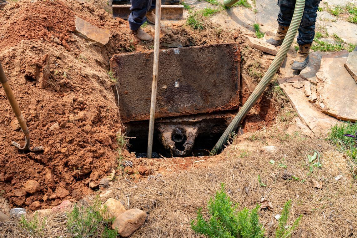 A manhole cover is being removed from a hole in the ground.
