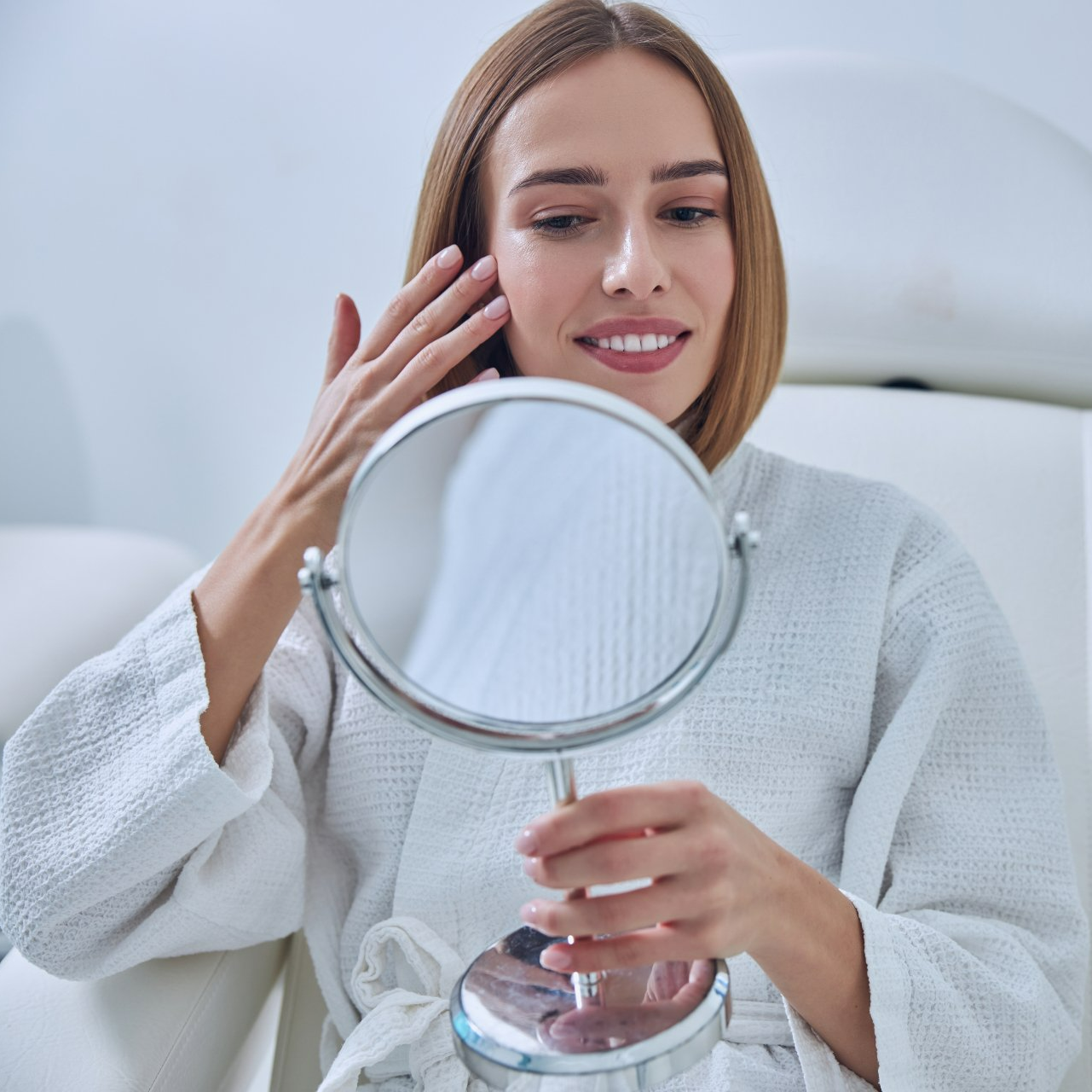 Attractive young female looking at a mirror enjoying professional advanced skin service