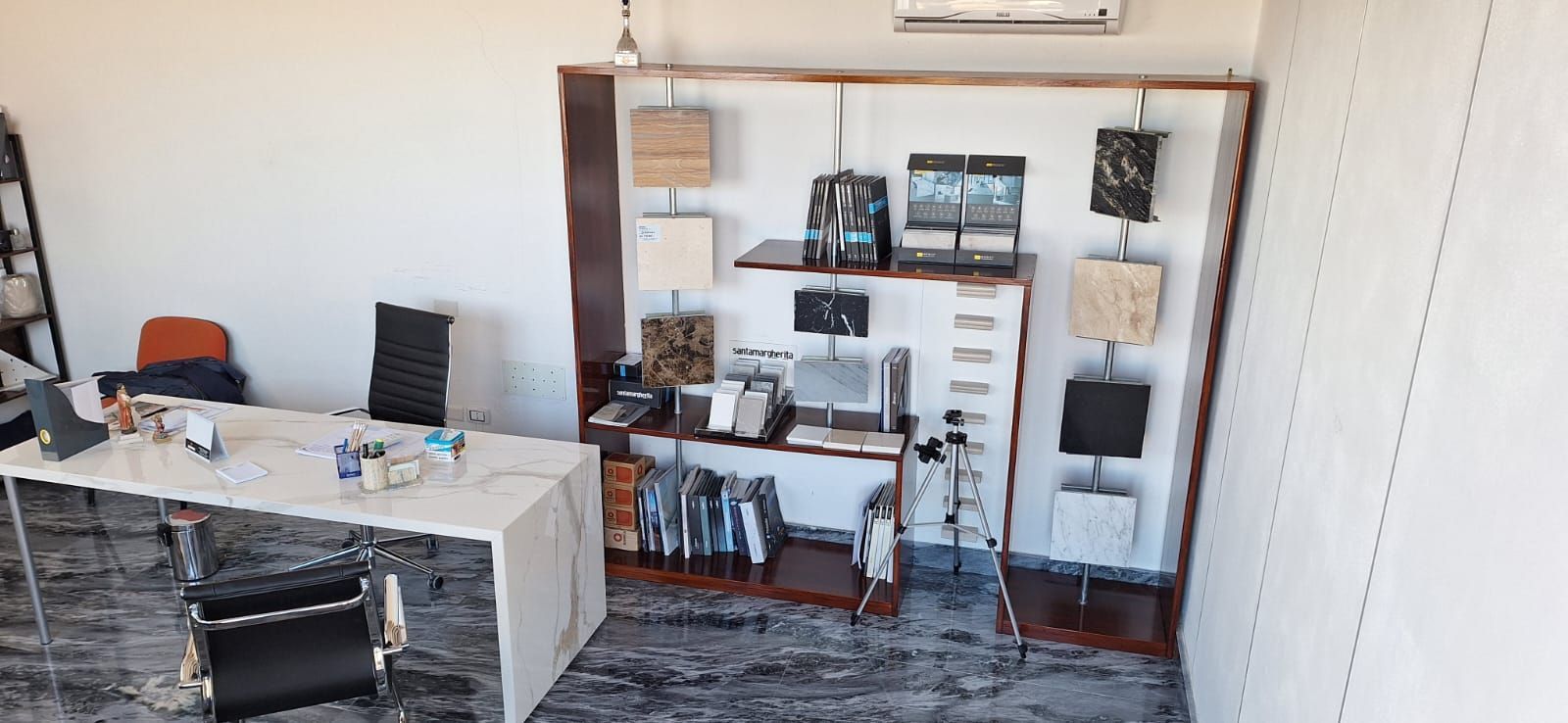 una stanza con scrivania, sedie, scaffali e lampade.