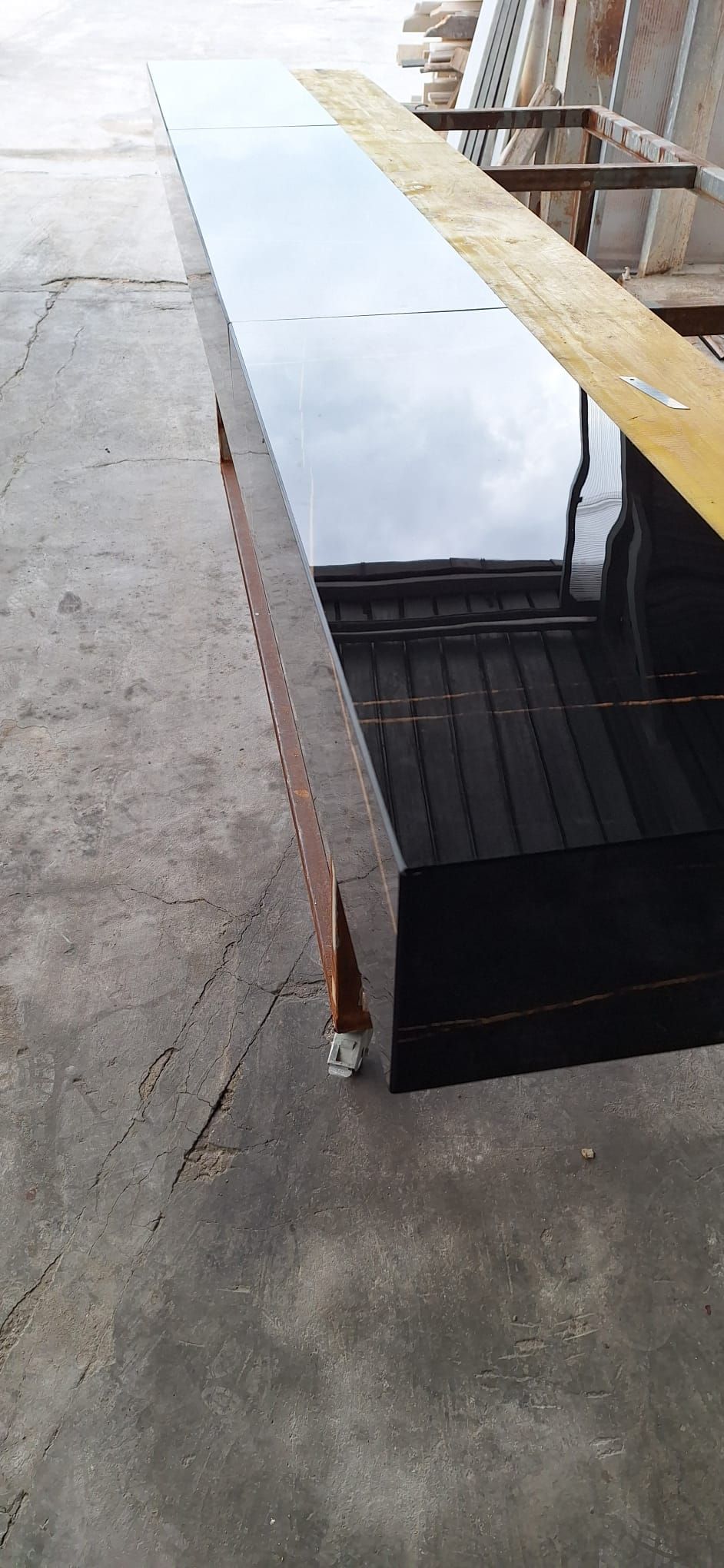 un lungo tavolo nero è appoggiato su un pavimento di cemento.