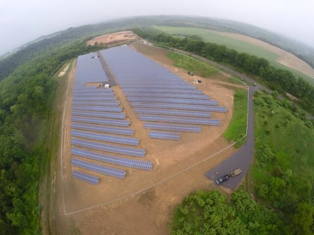 An aerial view of a solar farm in the middle of a field.