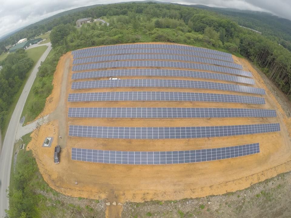 An aerial view of a large solar farm in the middle of a field.
