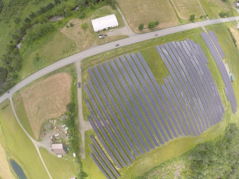 An aerial view of a large solar farm in a field.