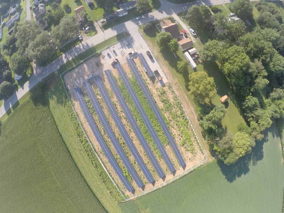 An aerial view of a field with rows of solar panels