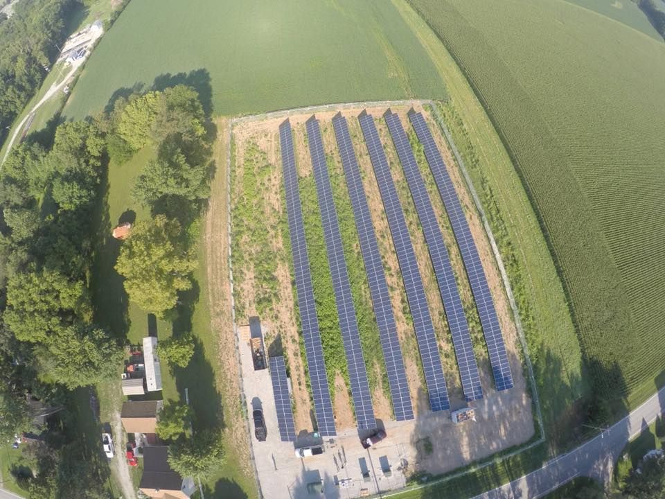 An aerial view of a field filled with solar panels.