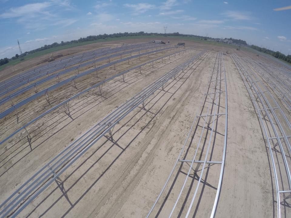 An aerial view of a row of solar panels in a field.