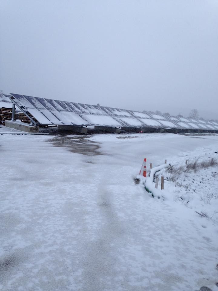 A snowy field with a building in the background