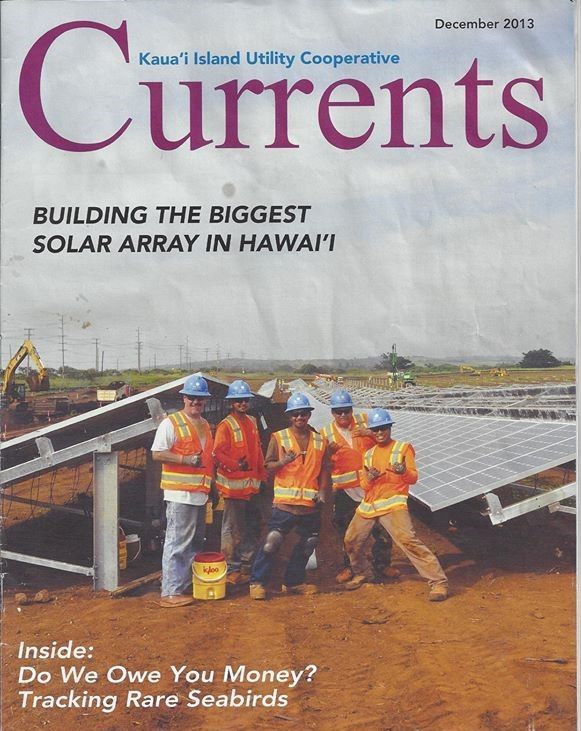 A currents magazine shows a group of construction workers on the cover