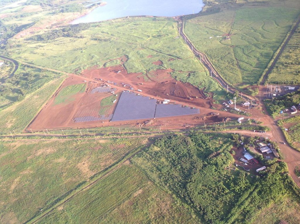 An aerial view of a large field with a lake in the background.