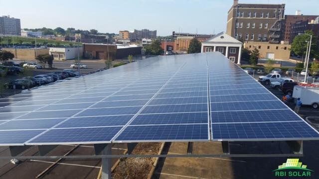 A lot of solar panels are sitting on top of a building