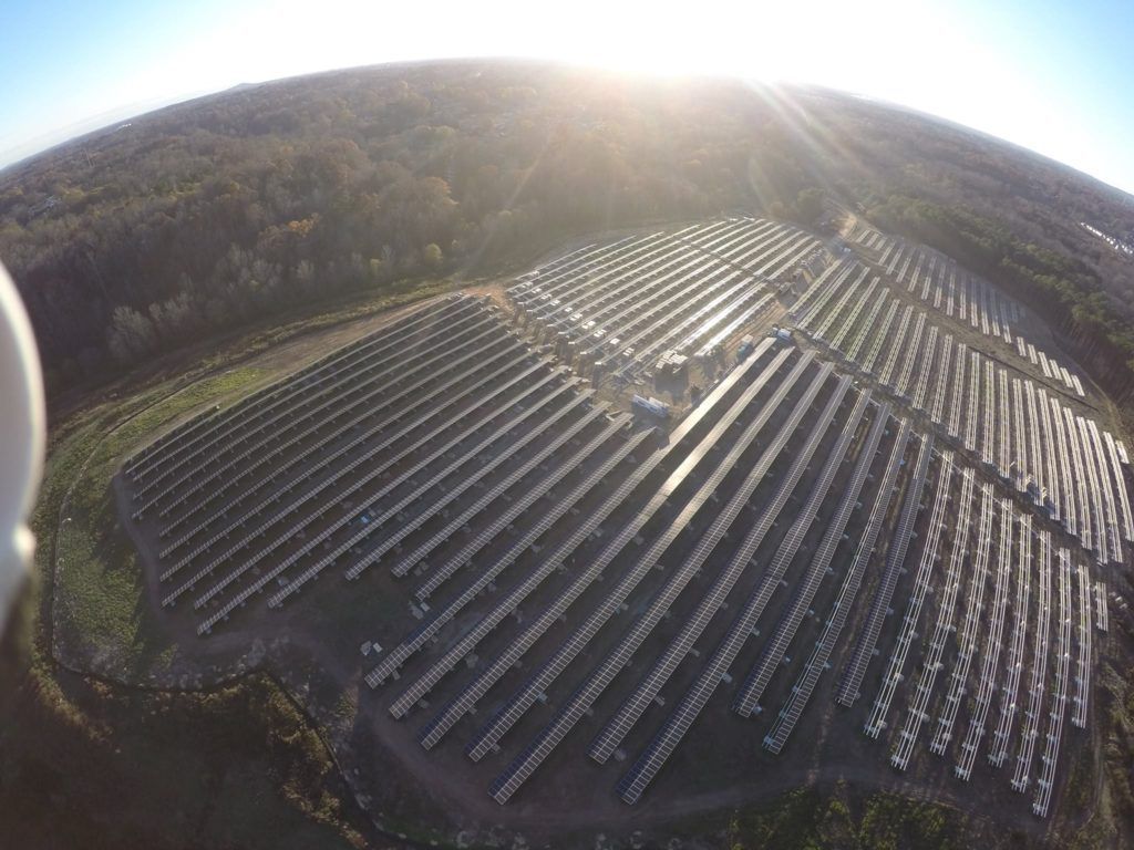 An aerial view of a large solar farm in the middle of a field.