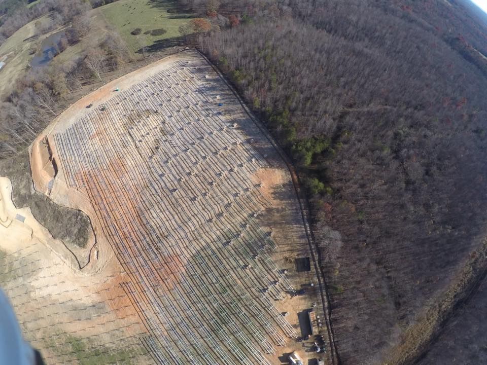 An aerial view of a large field surrounded by trees.