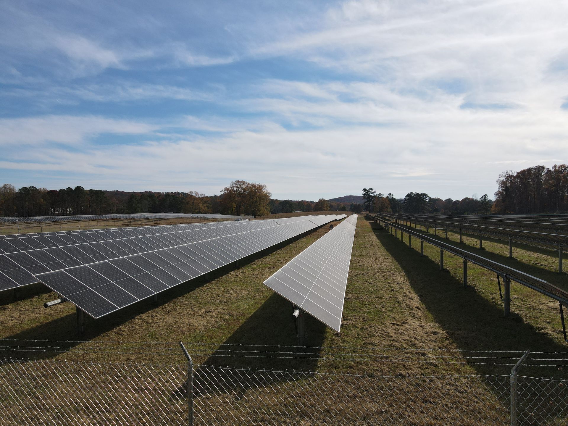 A row of solar panels sitting on top of a grassy field.