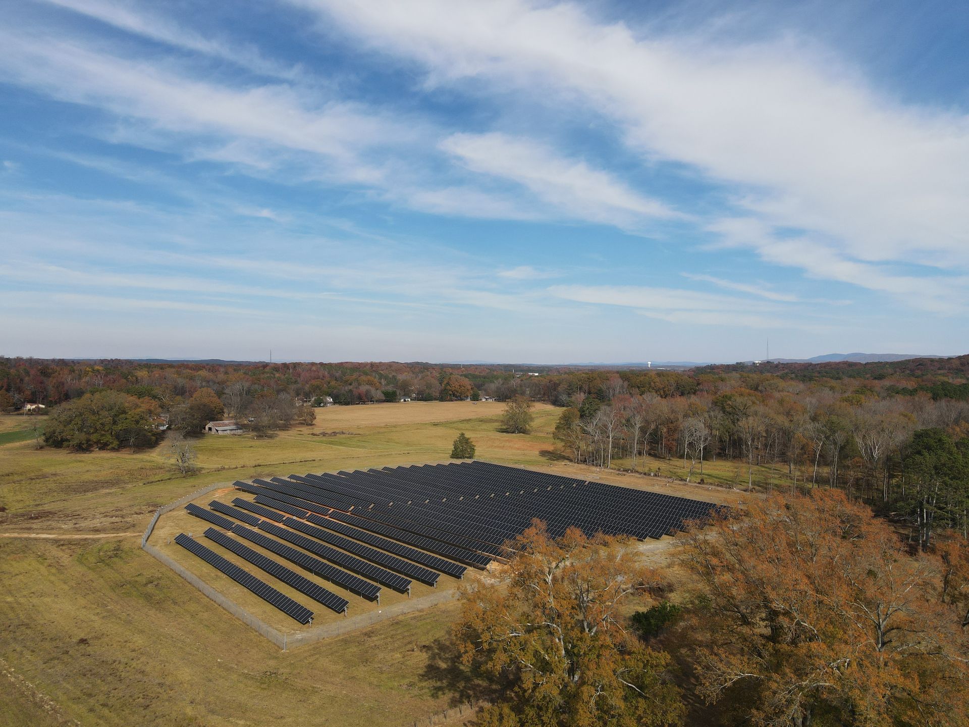 An aerial view of a large field filled with solar panels.