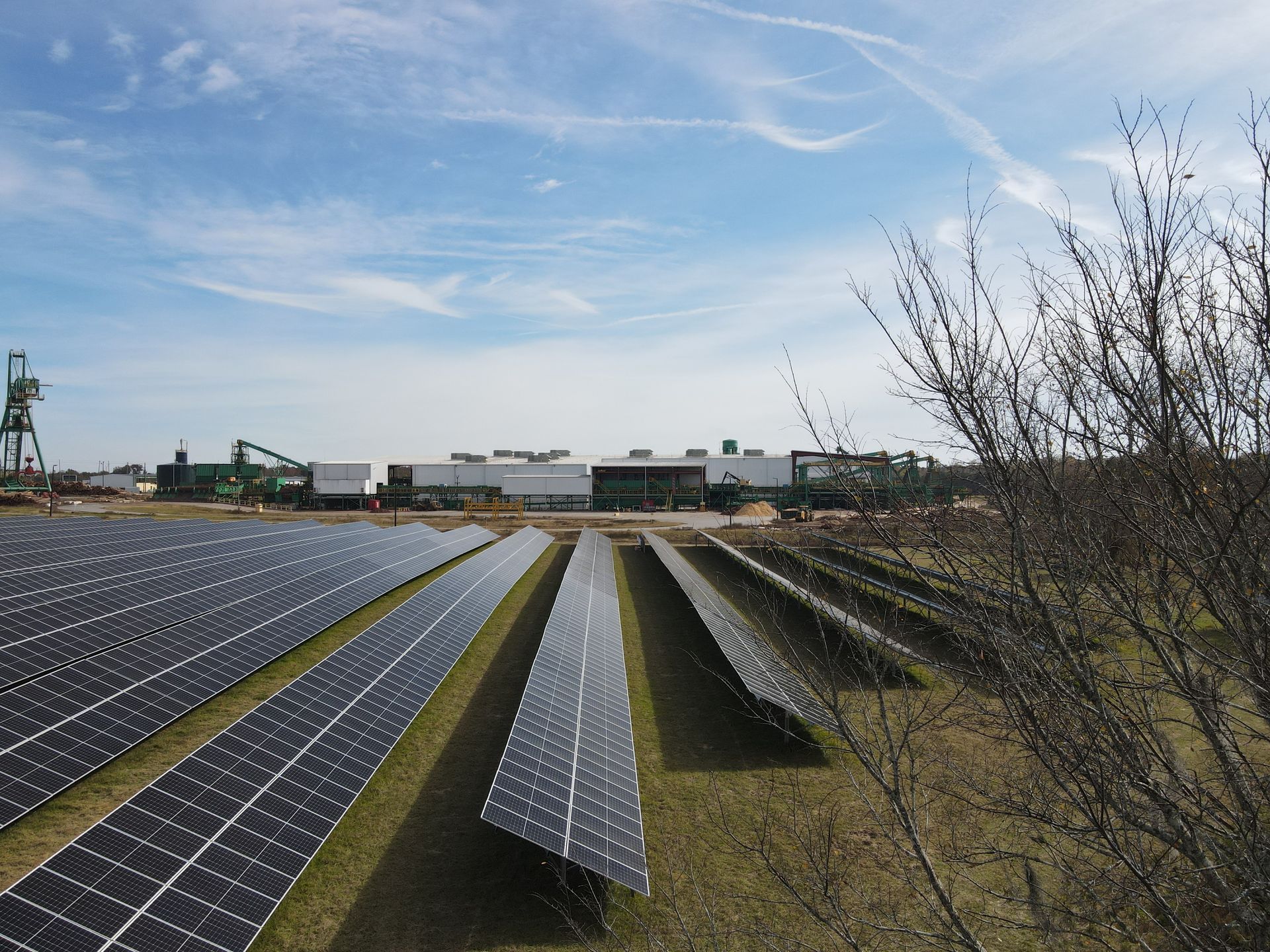 A field of solar panels with a building in the background