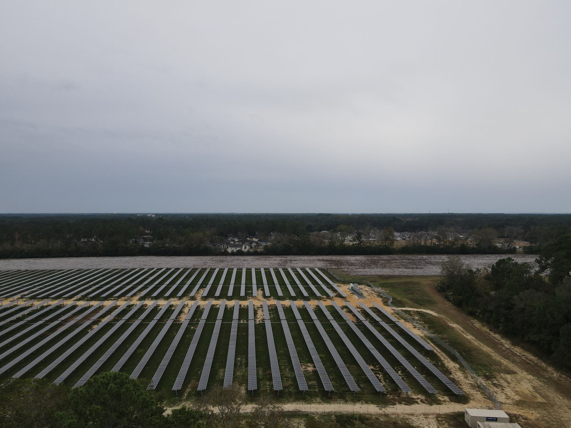 An aerial view of a large solar farm in the middle of a field.
