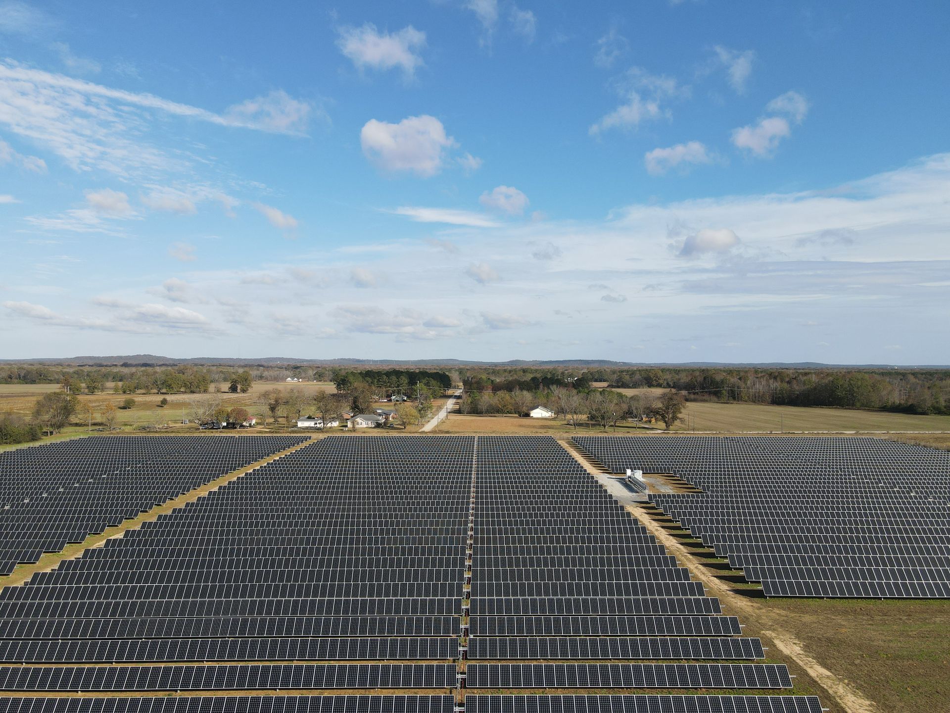 An aerial view of a large solar farm in a field.