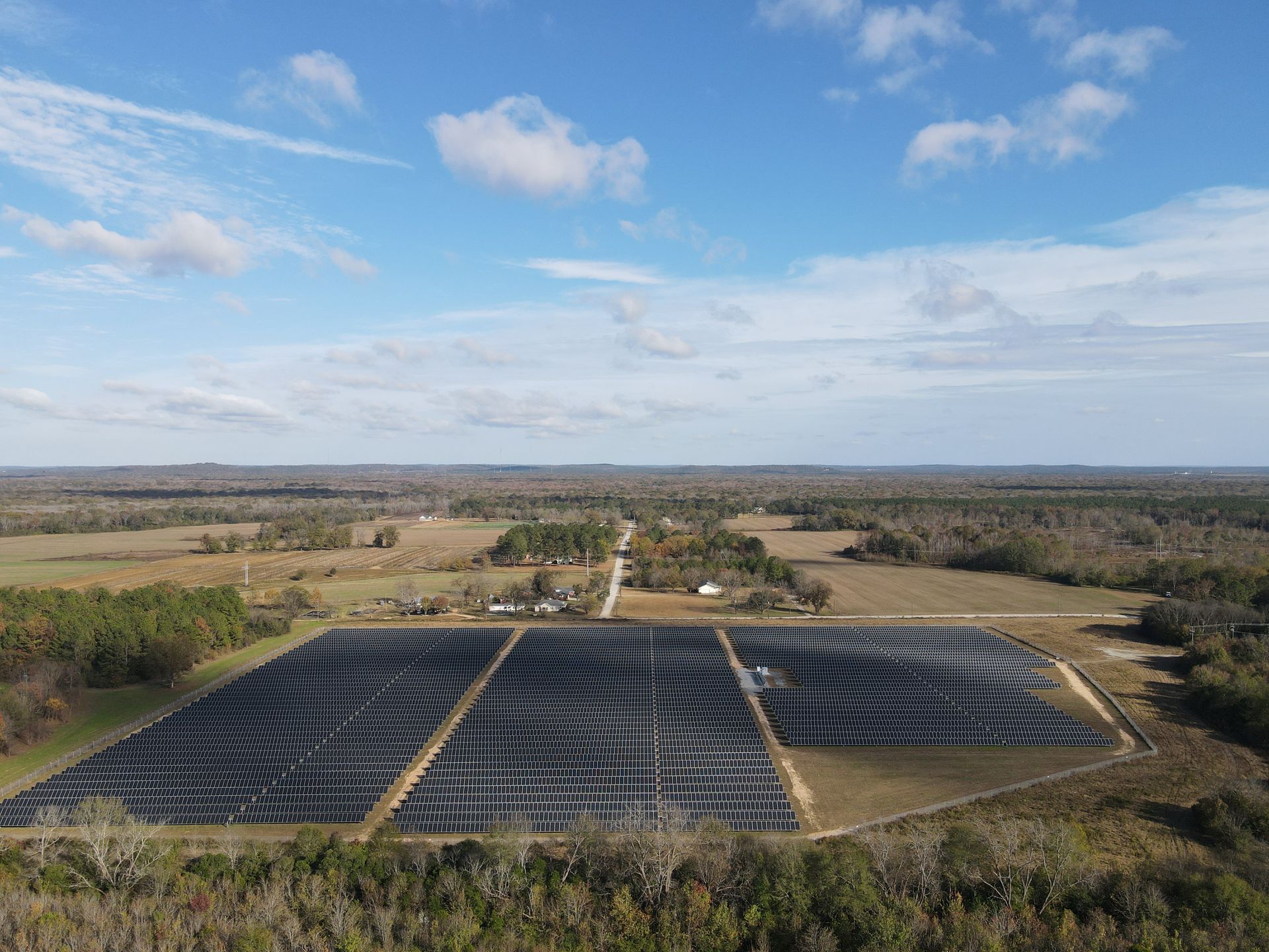 An aerial view of a large solar farm in the middle of a field.