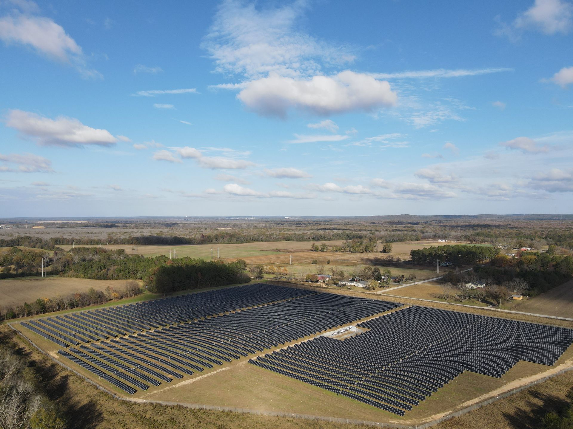 An aerial view of a large solar farm in a field.