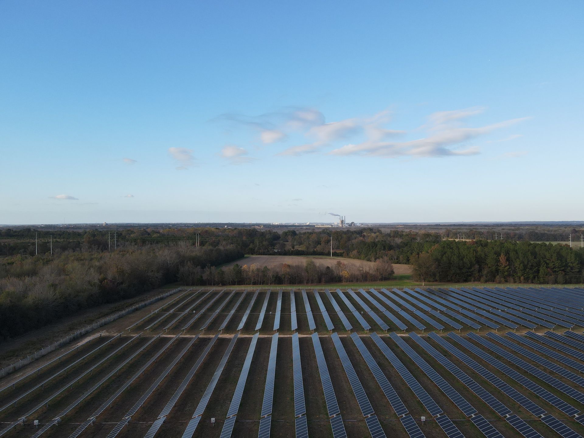 An aerial view of a field filled with rows of solar panels.