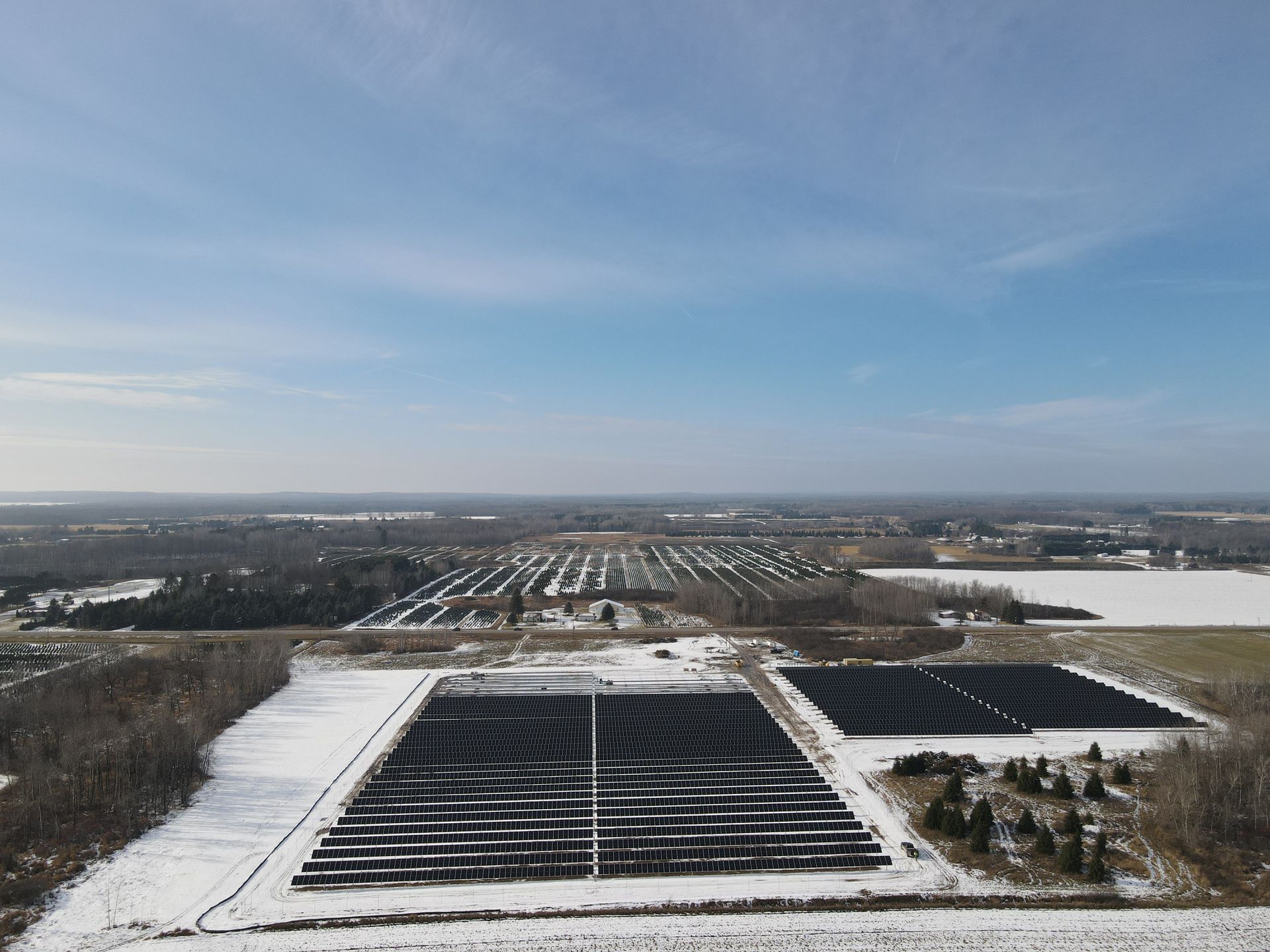 An aerial view of a solar farm in the snow.
