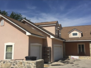 A house with a brown roof and a white garage door