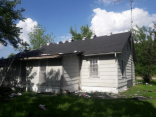 A small white house with a black roof