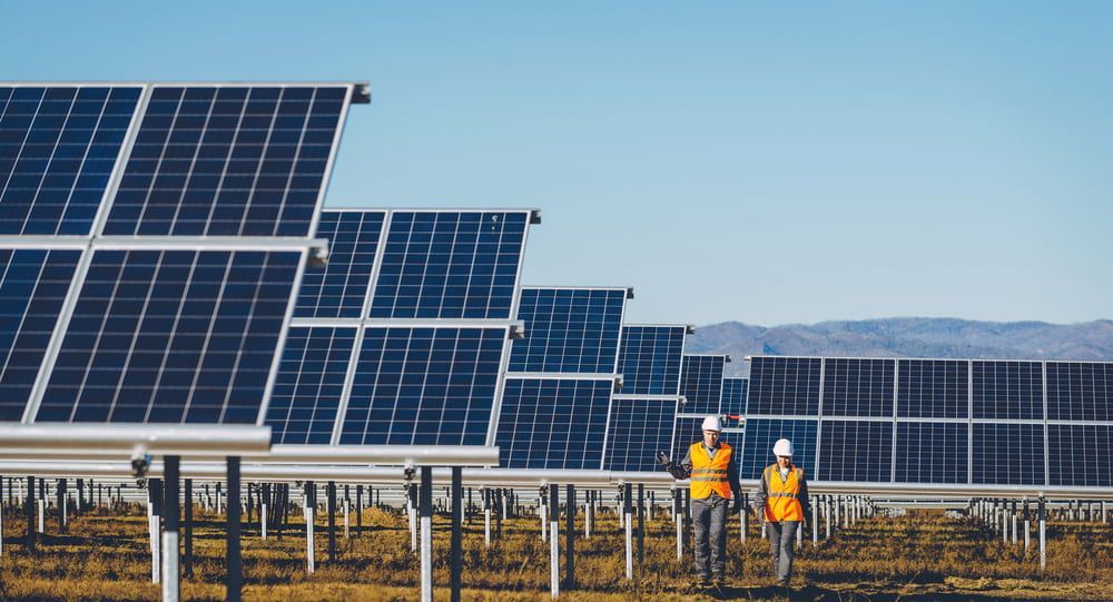 Two Men Are Walking Through A Field Of Solar Panels — Evolution Solar Kingaroy in Murgon, QLD