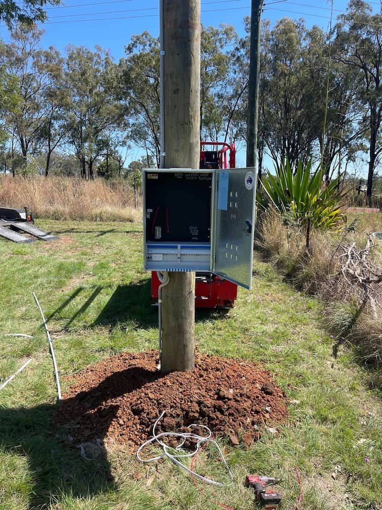 A Box Is Sitting on Top of A Wooden Pole in The Grass — Evolution Solar Kingaroy in Kingaroy, QLD