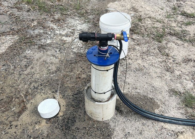 A Water Pump Is Sitting on Top of A Dirt Field Next to A Bucket — Evolution Solar Kingaroy in Kingaroy, QLD