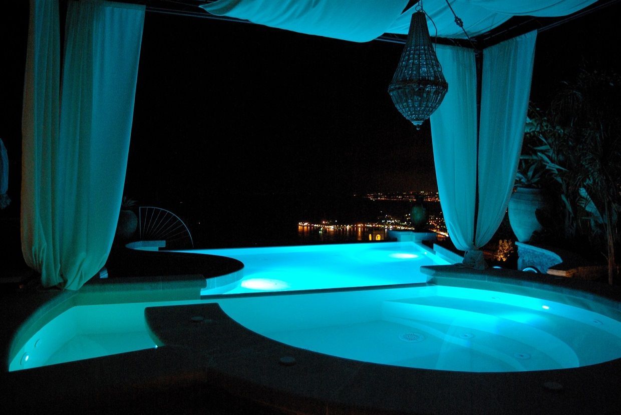 Una piscina è illuminata di notte sotto una tettoia