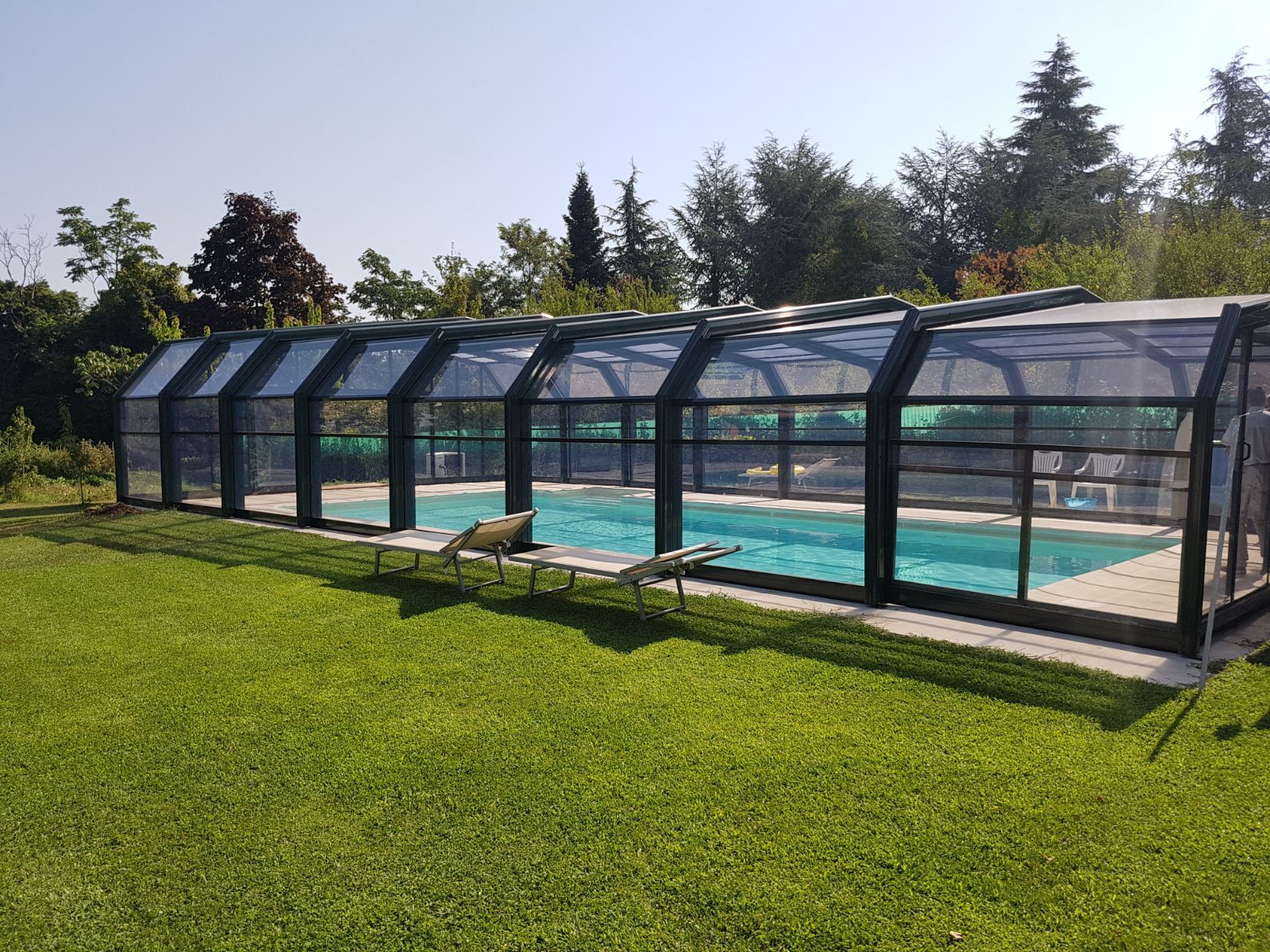 Una grande piscina con copertura coperta nel cortile sul retro.