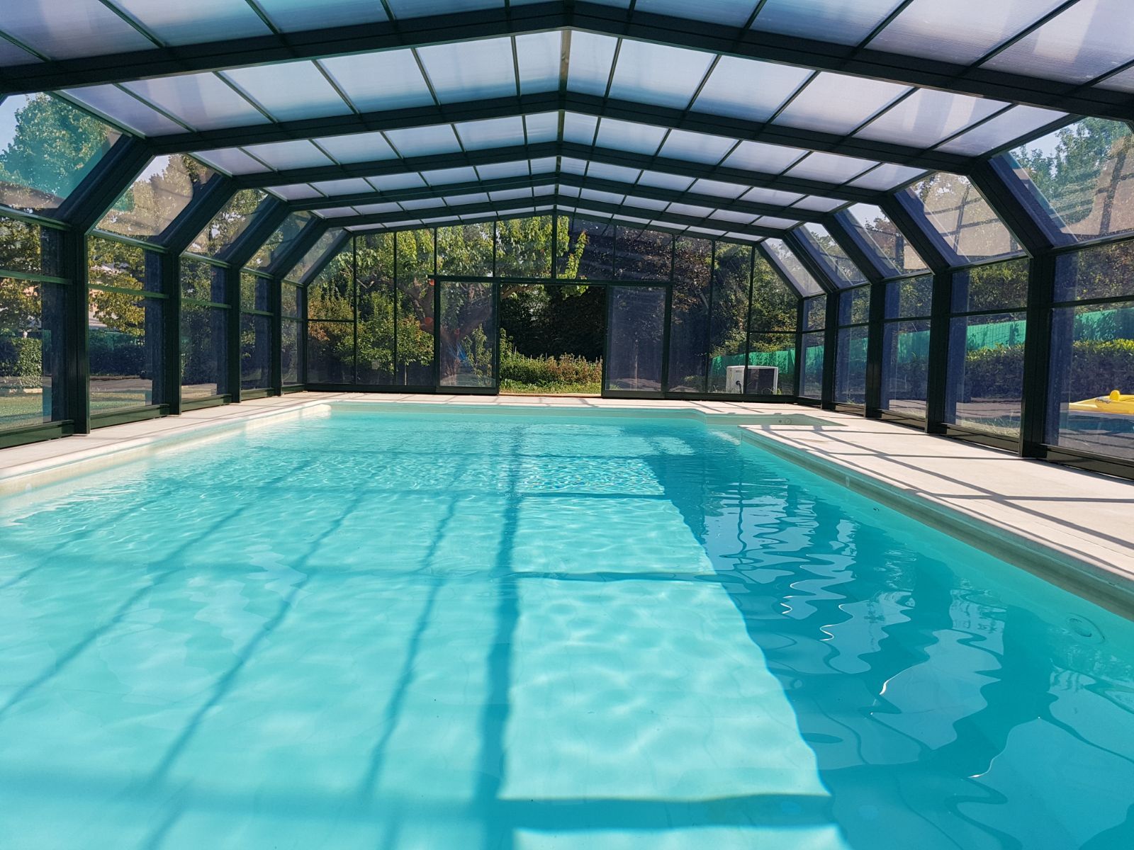 Una grande piscina coperta sotto un tetto coperto.