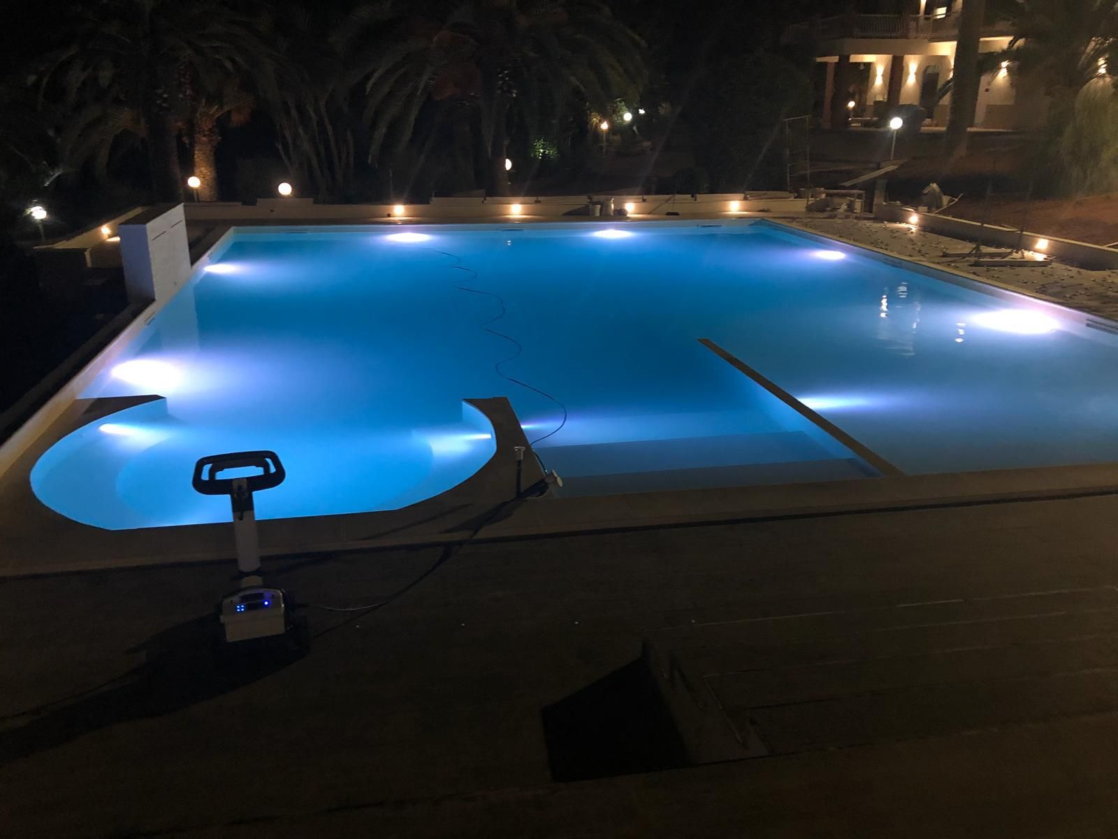 Una grande piscina è illuminata di notte