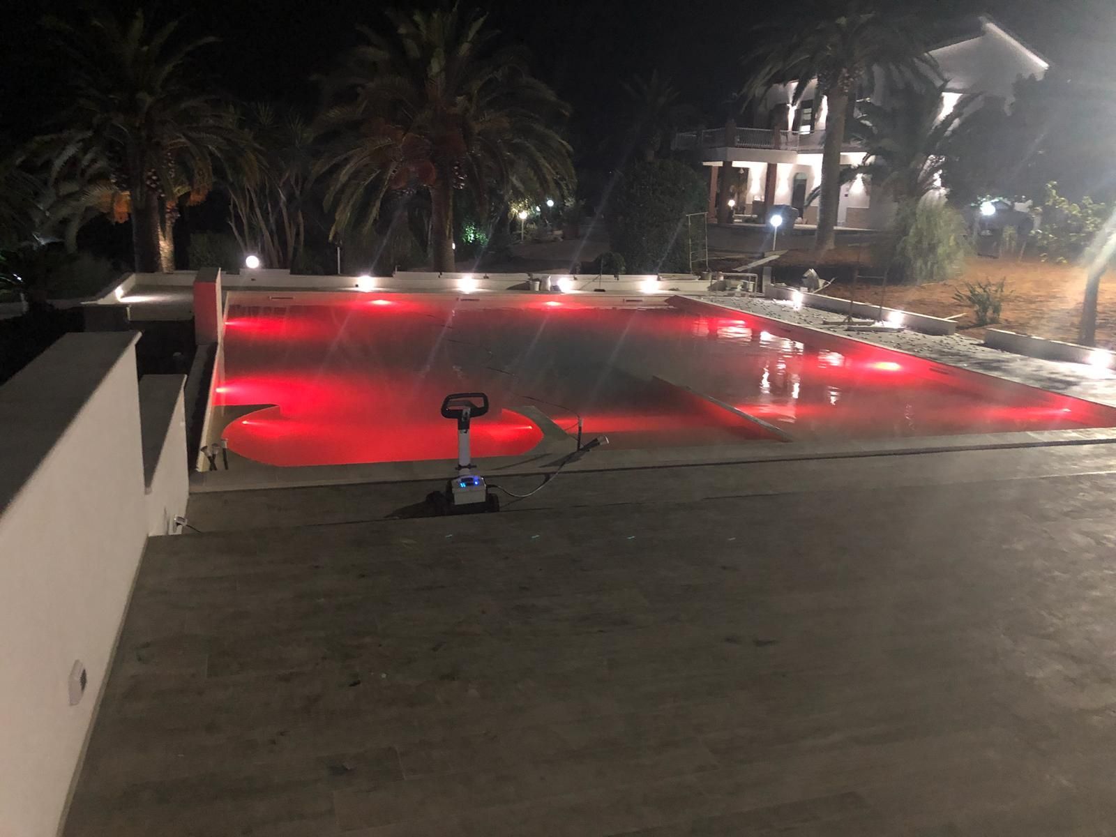 Una piscina è illuminata con luci rosse di notte