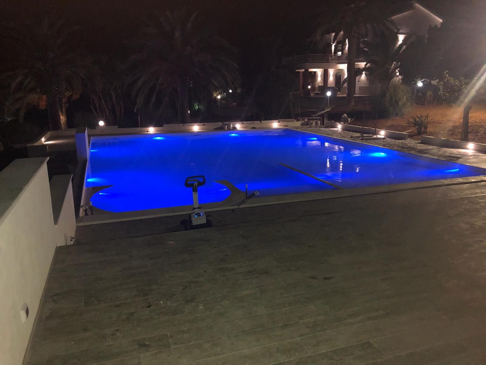 Una grande piscina è illuminata di notte