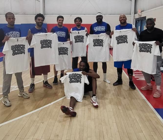 A group of men are posing for a picture on a basketball court