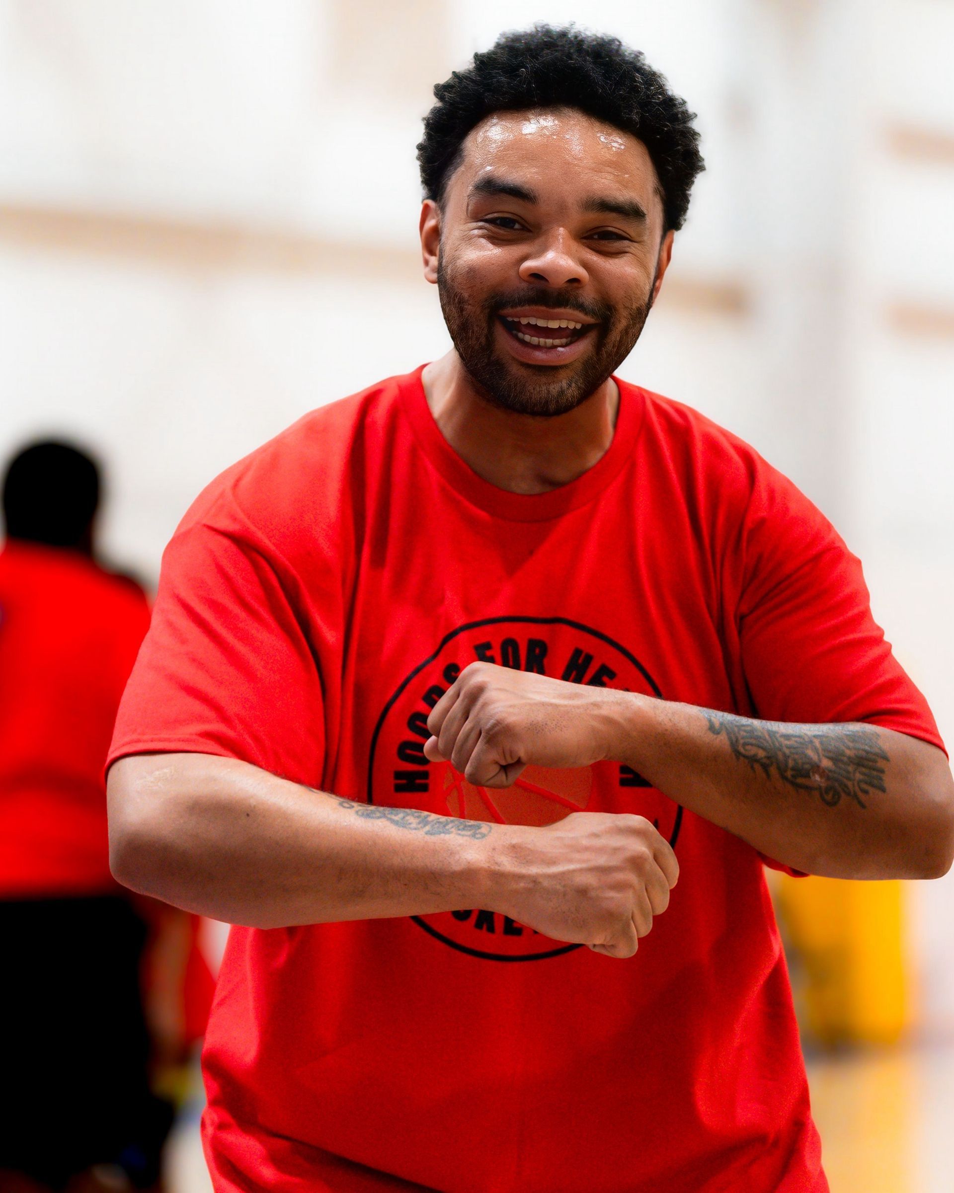 A man wearing a red shirt with a basketball on it