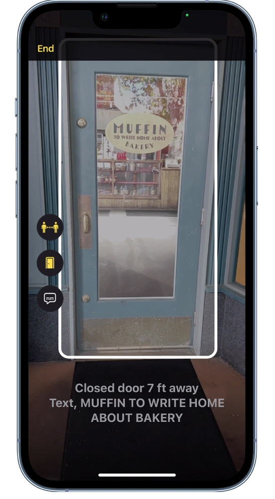 A phone is taking a picture of a blue door.