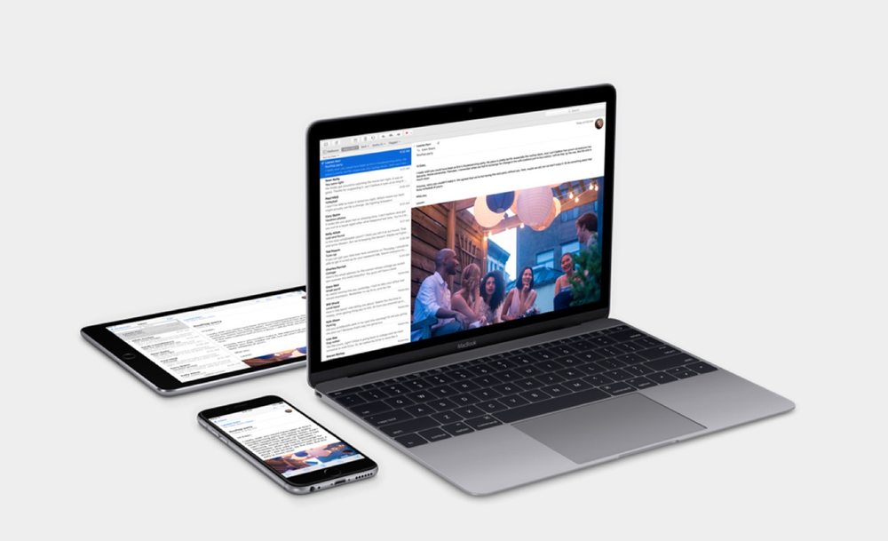 A laptop , tablet , and cell phone are sitting next to each other on a table.