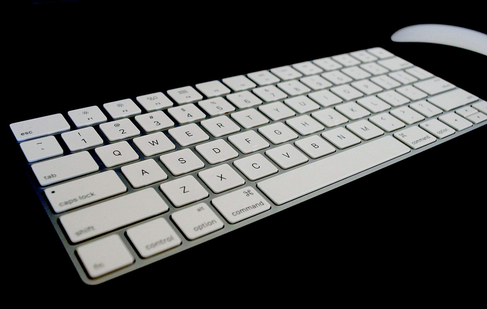 A close up of a keyboard and mouse on a black background