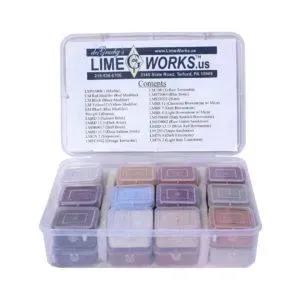 A clear plastic container filled with small square containers of various colored pigments.